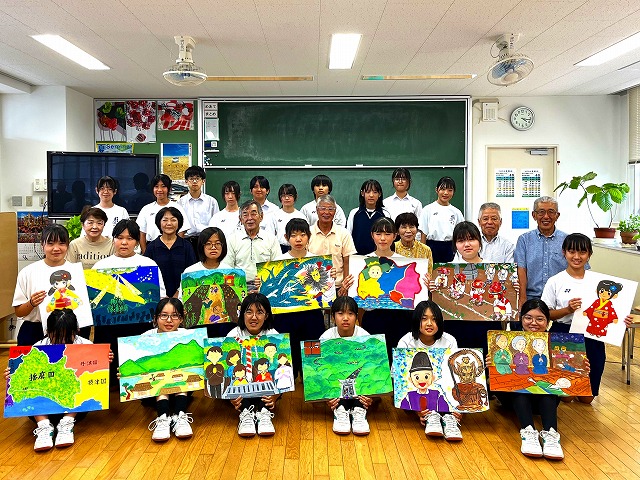 完成した絵を見せる中学生たち